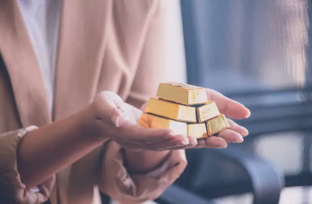 Woman holding gold bullion ,business and trading concept