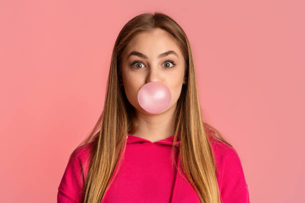 istock Bubble from chewing gum. Girl on pink background 1217959521
