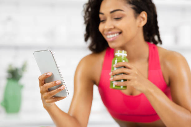 istock Smiling Girl Drinking Smoothie And Checking Social Media 1217960652