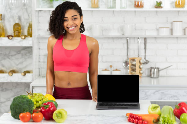 istock Black girl showing laptop with blank screen 1217960793