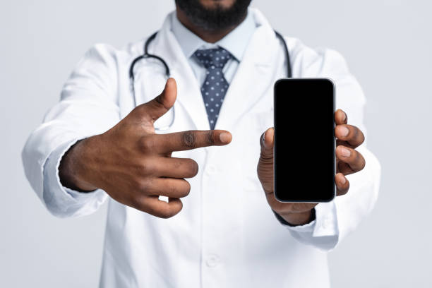istock Cropped of black doc pointing at empty phone screen 1217961206