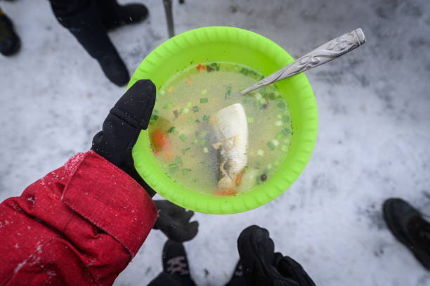 tourist hält eine heiße omul fischsuppe in der hand während des picknicks im baikalsee, russland. - baikalsee stock-fotos und bilder