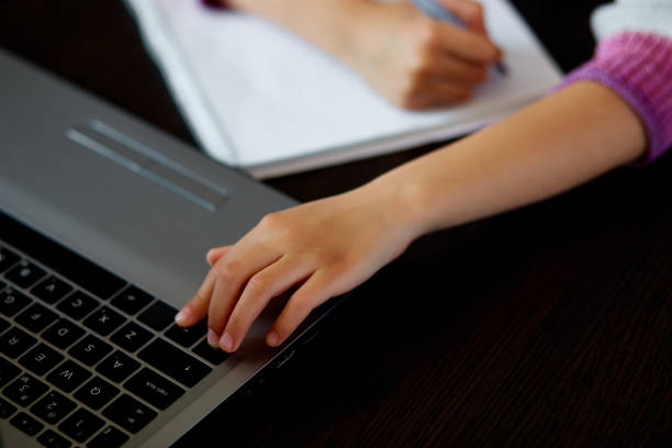 istock Unrecognizable Schoolgirl studying at home with a notebook and doing school homework. 1217962201