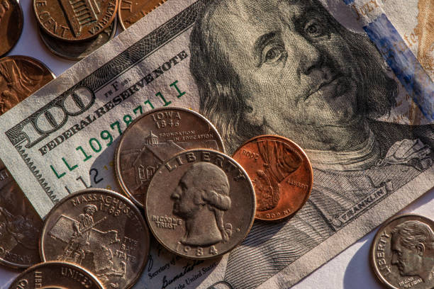 istock US american 100 bill bank note with coins 1217962211