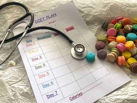Stethoscope and Diet plan form put beside colorful magaroons