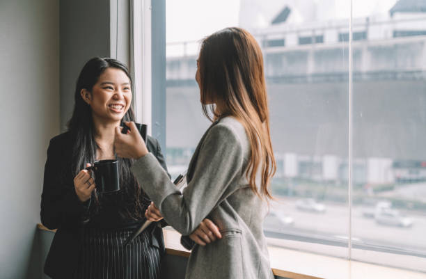 istock asian chinese female coworkers talking while having coffee in office 1217962482