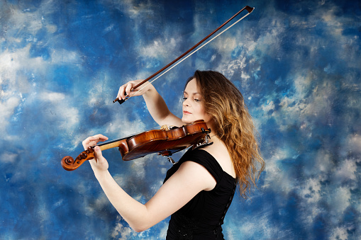 Young woman violinist finished playing on the street in Vienna.