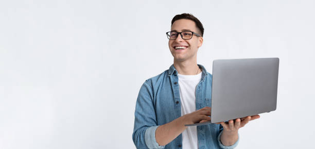 istock Laughing man in glasses and with laptop 1217963968