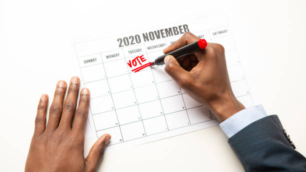 istock African man writing vote text in Calendar, US General Election 1217964877