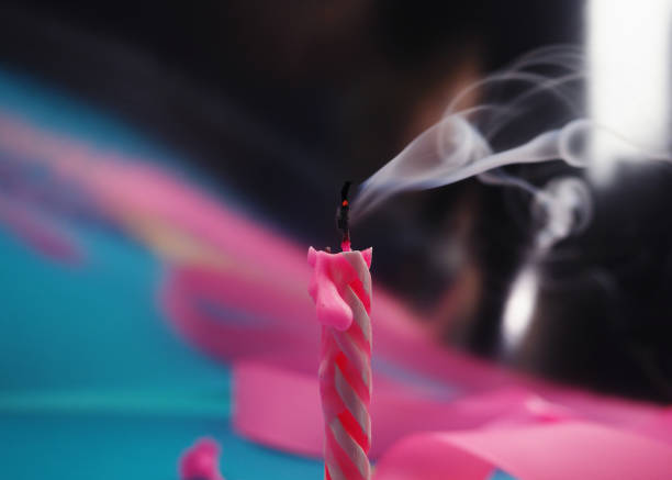 Extinguished candle with smoke trailing off the wick.