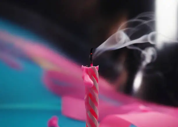 Photo of Extinguished candle with smoke trailing off the wick