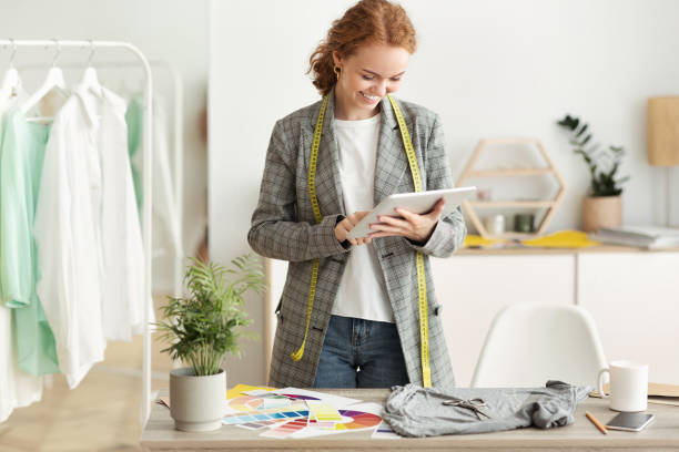 istock Fashion designer browsing new sketches collection on tablet 1217966389