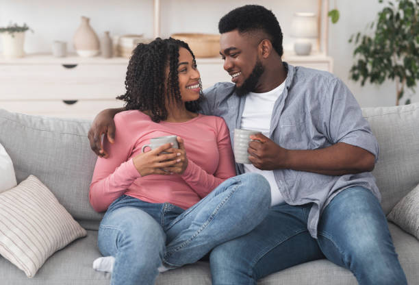 istock Quarantine Rest. Romantic Black Couple Relaxing On Couch With Coffee 1217966744