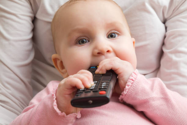 Infant Sitting In Mother Lap And Chewing Remote Control Closeup Front View  Favourite Baby Thing Stock Photo - Download Image Now - iStock