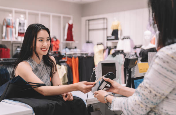 customer making credit card payment at cashier counter in clothing store at shopping mall shopping scenario asian cashier stock pictures, royalty-free photos & images