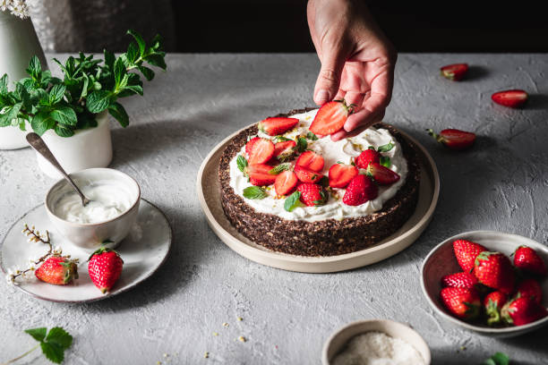 istock Chef garnishing yogurt pie with fresh strawberries 1217971186
