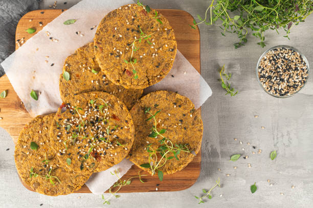 Raw veggie burger with lentils, vegetables and thyme leaves on kitchen countertop. Top view. Flat lay