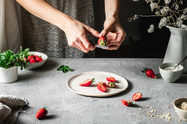 istock Female chef chopping strawberries to prepare a pie 1217972770