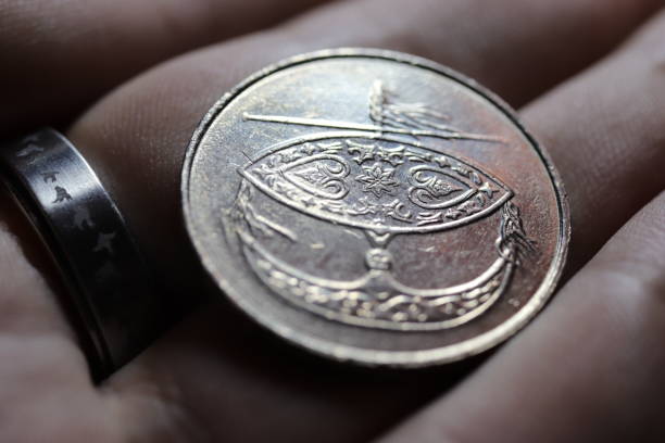 istock 50 sen coin in hand with steel ring 1217973503