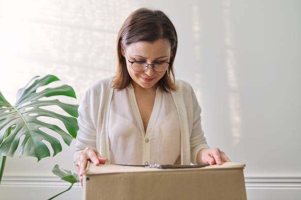 istock Woman with packaged package, cardboard box. Service for postal delivery 1217974870