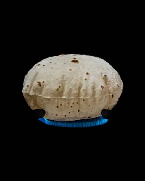 Phulka is a smaller round bread, prepared from wheat dough whose one side is cooked on a tawa and the other side directly on heat. When placed immediately thereafter on hot embers, the bread puffs up to yield a phulka. The phulka puffs up into a ball due to accumulation of steam inside it.