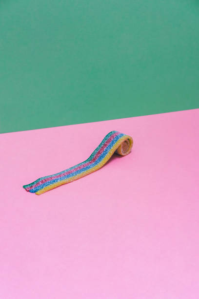 istock One rainbow chewable candy gum on pink and green background. Minimal art. 1217980607