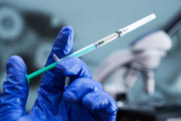 istock Virologist's hand in glove holding syringe. 1217982723