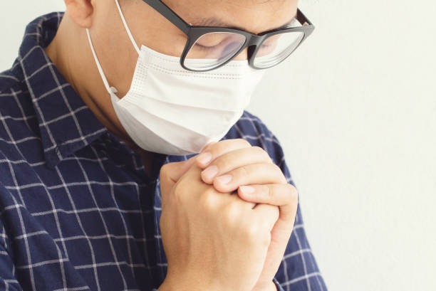 istock Man wearing protective mask against the coronavirus, doing pray for corona virus is overcome.Novel coronavirus - 2019-nCoV, WUHAN virus concept. 1217982745