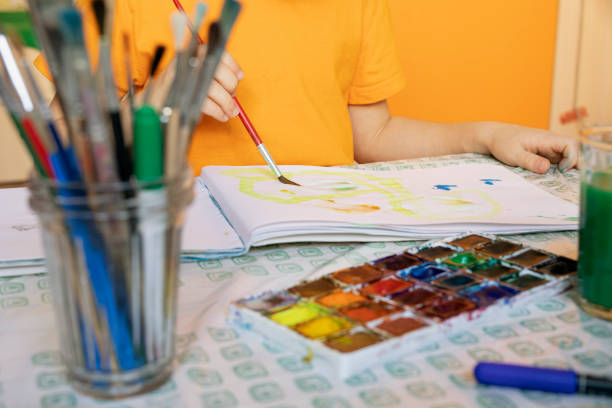 istock drawing materials on blurred background and child is painting. creative activities and leisure for children at home 1217984103