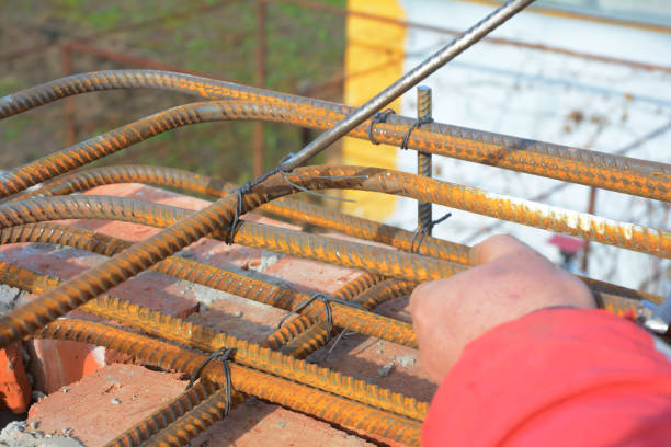 istock Building contractor reinforcing corner with iron bars with wire rod. Builder making iron bars lintels for house construction. 1217984610