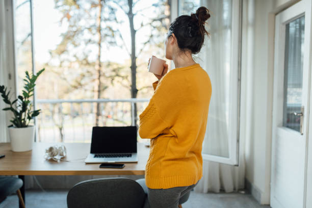 istock Young woman in quarantine drinking coffee and relaxing 1217984899