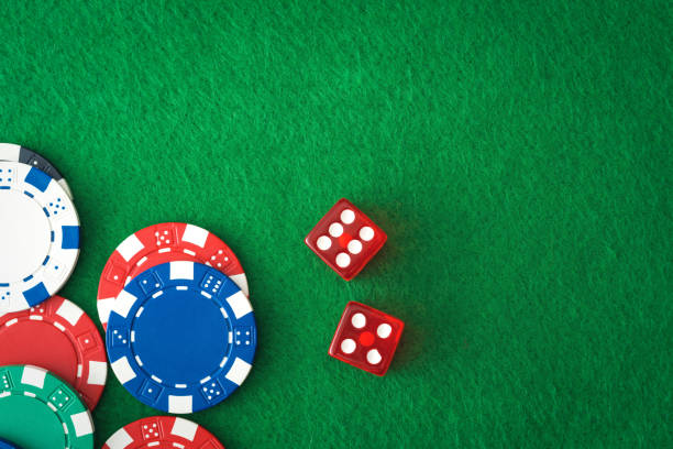 istock Casino chips and red dices on green empty felt 1217985157