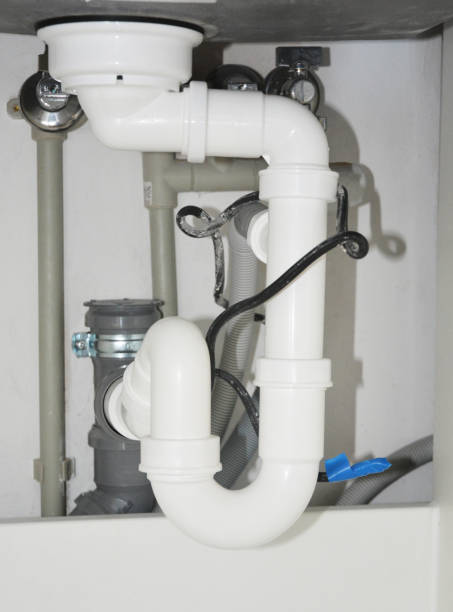 istock Close up on ceramic kitchen sink installation with sink drain tubes plumbing. 1217985866