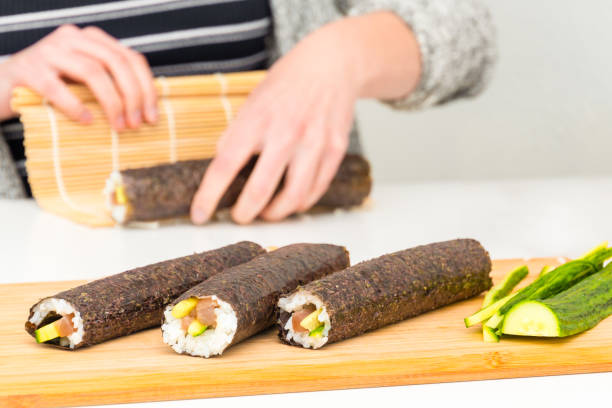 Sushi roll Japanese food preparing makis by hand stock photo