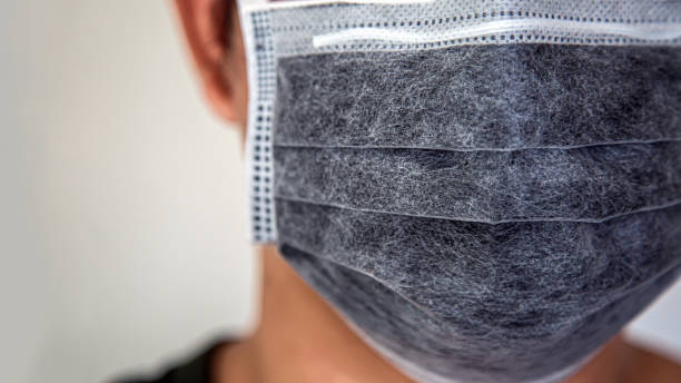 istock portrait an Asian man wearing a flu mask learning a white wall with blank right side for copy space 1217986430