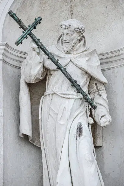 Photo of Saint George statue with big cross at the facade of Church of San Giorgio Maggiore in Venice, Italy, summer, details