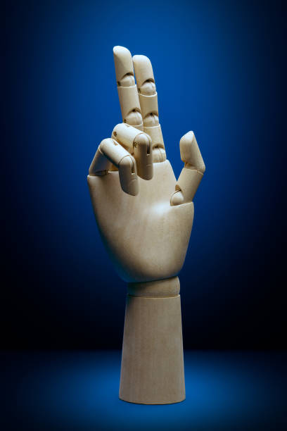 istock Artificial intelligence wooden hand front view with two fingers pointing up 1217993862