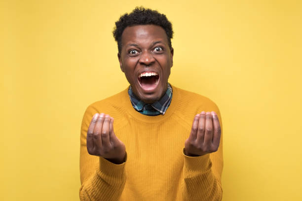 istock African man looking angry showing italian gesture over yellow background 1217995892