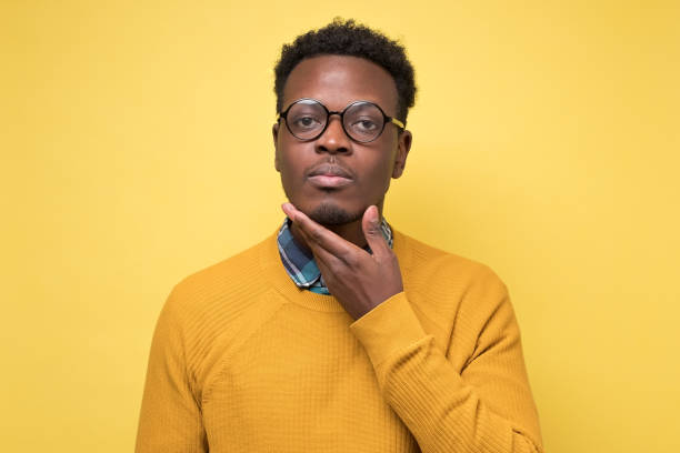 istock Handsome pensive afro american man in yellow clothes looking and thinking 1217996228