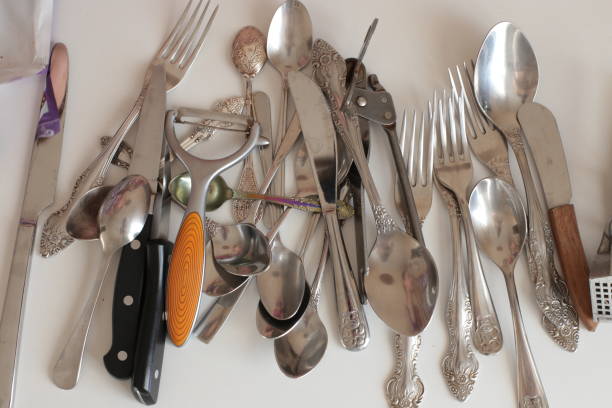 istock empty dinnerware on white table background. household items: spoons, forks, knives 1217996361