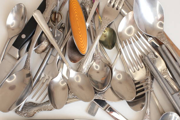 istock empty dinnerware on white table background. household items: spoons, forks, knives 1217996387