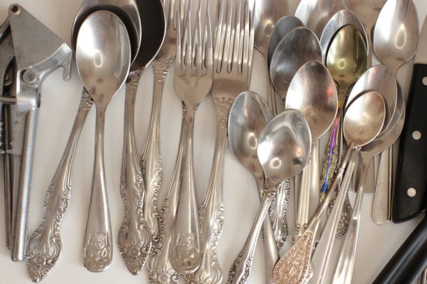 istock empty dinnerware on white table background. household items: spoons, forks, knives 1217996446
