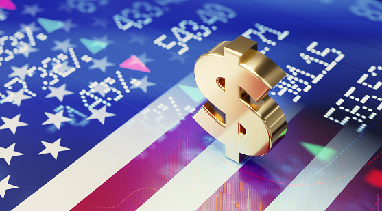 American dollar sign sitting over American flag and blue financial bar graph. Selective focus. Horizontal composition with copy space. American stock market and finance concept.