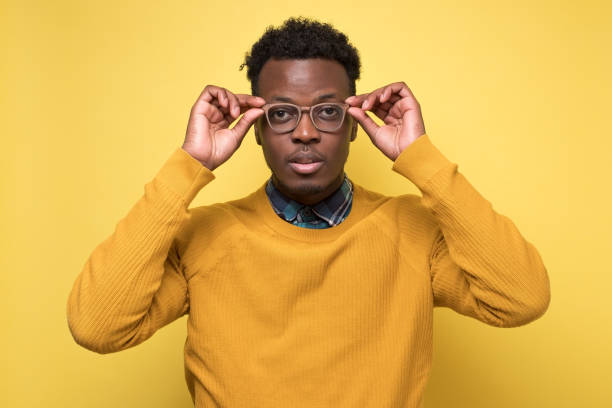 istock African american cheerful satisfied guy taking on his new glasses 1217997612