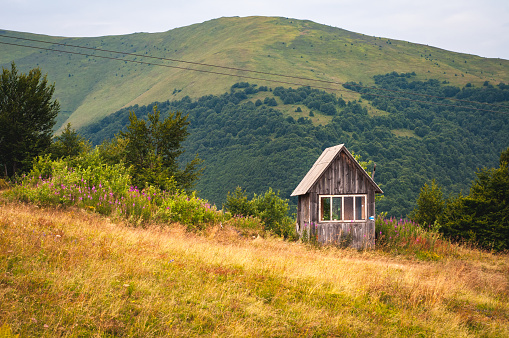 A small wooden house in the mountains on the beautiful slope of Gimba Mountain in the Carpathians.