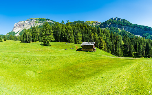 Picturesque spring rural landscape with rickety wooden hut and high snowy Piatra Craiului mountains, Pestera village, Transylvania, Romania, Europe