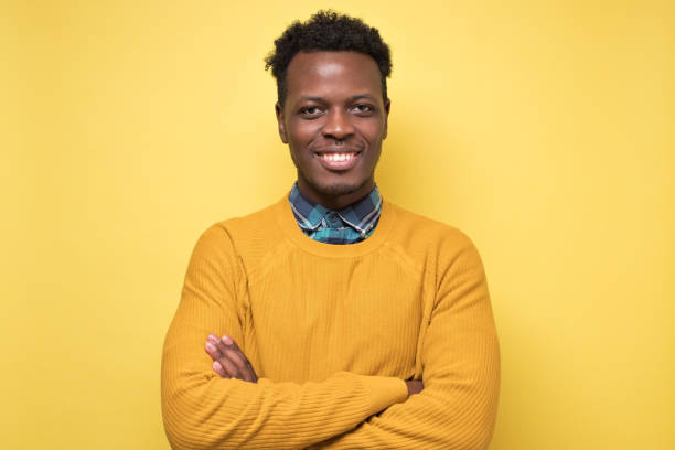istock Young african man with arms crossed smiling at camera 1217999140