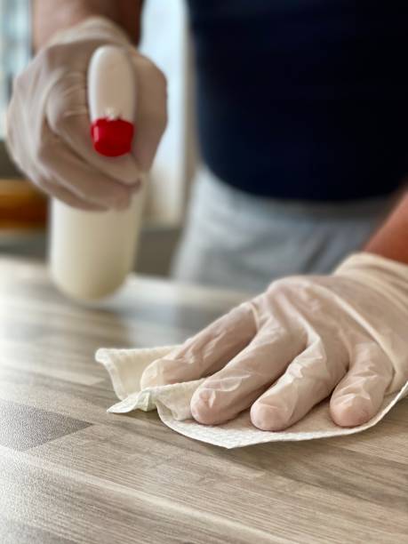 istock Man cleaning disinfecting table 1217999198