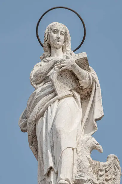 Photo of Ancient aged sculpture of beautiful Holy Maria at roof of Santa Maria Assunta Jesuits Church in Venice, Italy, details, closeup