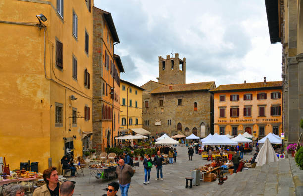 Cortona Italy Cityscape with medieval buildings and people with street market on Piazza Signorelli Square in historical center in former Etruscan town Cortona, Tuscany Cortona Italy 28.04.2019. Cityscape with medieval buildings and people with street market on Piazza Signorelli Square in historical center in former Etruscan town Cortona, Tuscany cortona stock pictures, royalty-free photos & images